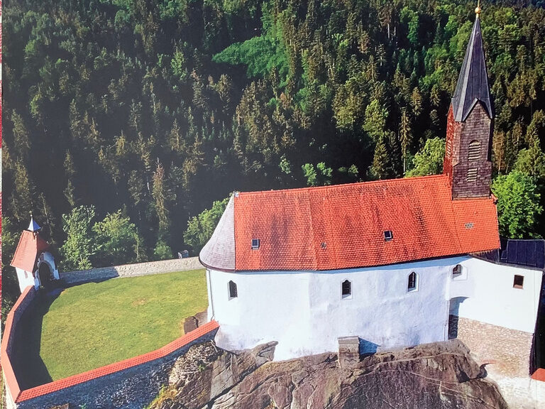 Eine beeindruckende Kirche mit einem imposanten Turm auf einem Hügel.