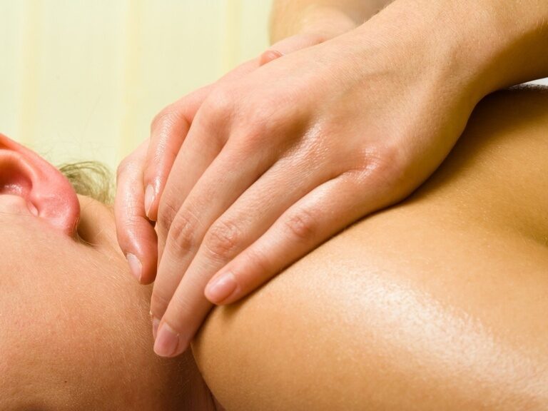 Eine Frau erhält eine entspannende Rückenmassage im Wellnessbereich.